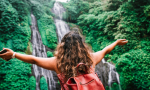 Solo Explorer Admiring Waterfall in a Dense Forest